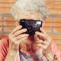 Activiteitenbegeleider oude vrouw met camera